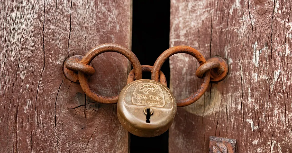 Vieux cadenas fermant une porte en bois