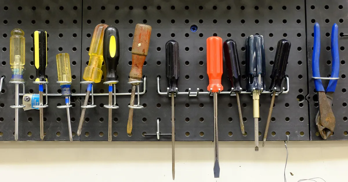 Outils rangés sur un panneau perforé d'atelier