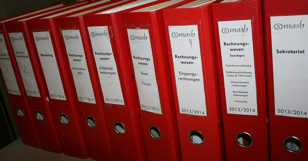 Classeurs rouges alignés sur une étagère