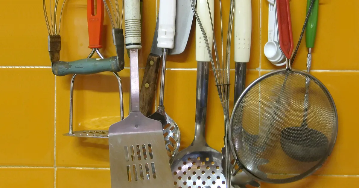 Ustensiles de cuisine accrochés à un mur carrelé