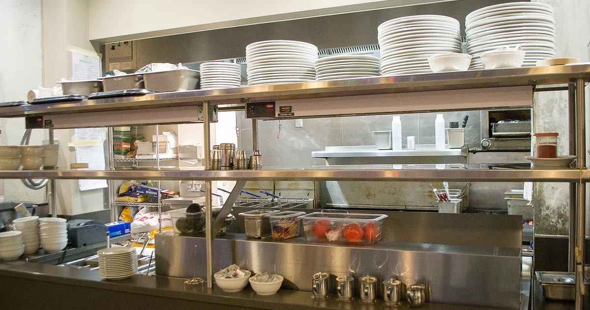 Passavivande di una cucina di ristorante e pile di piatti